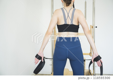 マシンピラティスをする若い女性の後ろ姿 イメージ マシンピラティスをする若い女性の後ろ姿 イメージ 118593300