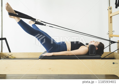 マシンを使ってピラティスをする若い女性  マシンを使ってピラティスをする若い女性  118593401
