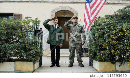 American Military Man And Veteran Greeting Father And Son In Front Of House American Military Man And Veteran Greeting Father And Son In Front Of House 118593659