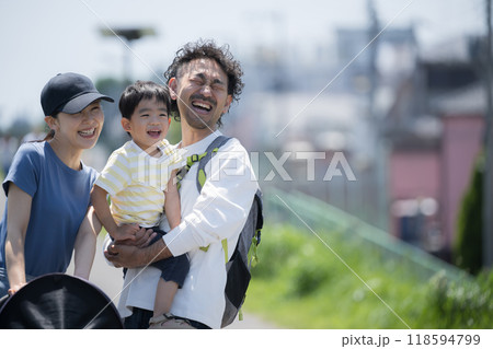 公園で散歩する親子(4人家族)の上半身　春夏のお出かけやレジャーなどのイメージ　笑顔で大笑いで見上げ 118594799
