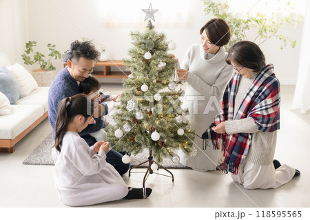 クリスマスツリーの飾り付けをする家族　母と父と祖母と娘と息子と赤ちゃん 118595565