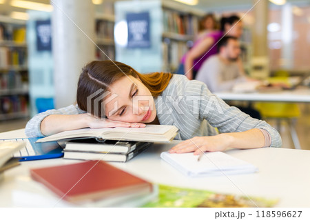 Portrait young tired student girl in the library Portrait young tired student girl in the library 118596627