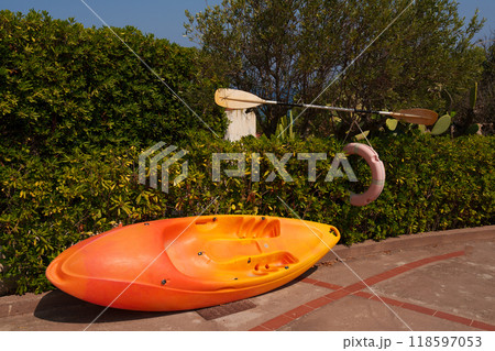 Bright Orange Kayak with Paddle and Life Ring in Garden Bright Orange Kayak with Paddle and Life Ring in Garden 118597053