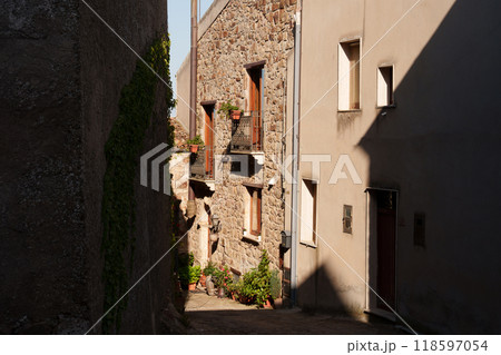 Narrow Mediterranean village alley with stone buildings and potted plants Narrow Mediterranean village alley with stone buildings and potted plants 118597054