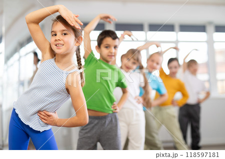 Children do warm-up exercises in studio, prepare for pair dance class Children do warm-up exercises in studio, prepare for pair dance class 118597181