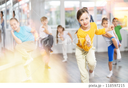 Girl learn to dance hip hop dances, doing movement with unrecognizable teacher. Girl learn to dance hip hop dances, doing movement with unrecognizable teacher. 118597215