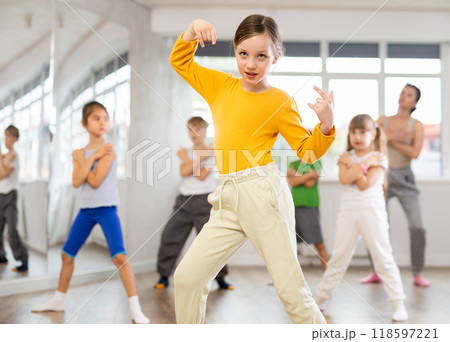 Girl learn to dance modern dances, doing movement with unrecognizable teacher. Girl learn to dance modern dances, doing movement with unrecognizable teacher. 118597221