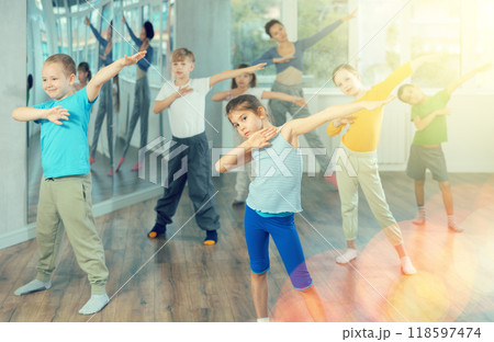 Girl learn to dance modern dances, doing movement with unrecognizable teacher. 118597474