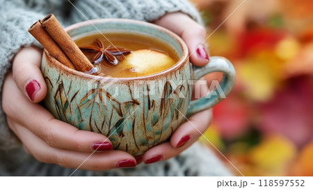 A Hand Holding a Mug of Warm Spiced Drink with Cinnamon Sticks and Star Anise A Hand Holding a Mug of Warm Spiced Drink with Cinnamon Sticks and Star Anise 118597552