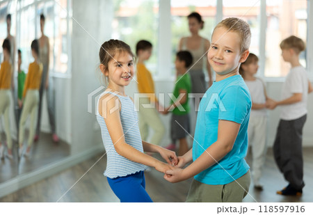 Girl paired up with boy and training to perform slow couple dance, rehearse performance. Girl paired up with boy and training to perform slow couple dance, rehearse performance. 118597916