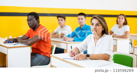 Portrait of focused female studying in classroom with colleagues Portrait of focused female studying in classroom with colleagues 118598269