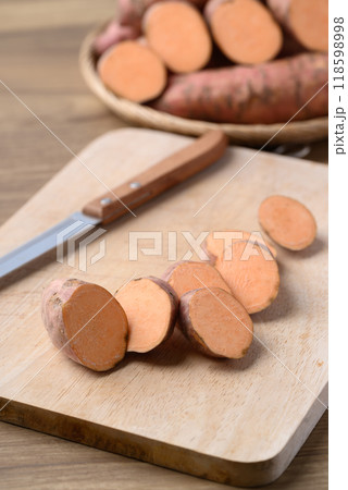 Raw organic Japanese sweet potatoes on cutting wooden board prepare for cooking 118598998