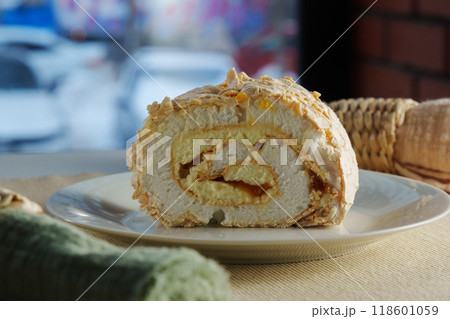 Delightful dessert roll served on a plate with a vibrant background showcasing urban life in the late afternoon Delightful dessert roll served on a plate with a vibrant background showcasing urban life in the late afternoon 118601059