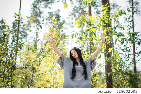 A young girl who breathes fresh air and relieves stress in the forest. 118602983