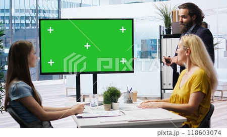 Broker in office offering financial advice to clients, looking at forex index values on green screen display. Financial advisor analyzing customers market shares on chroma key device, camera A 118603074