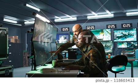 Team of army telecommunications operators using radio and satellite gear, cooperating to provide combat support. Teamworking military dispatchers colleagues managing communications networks, camera B 118603413
