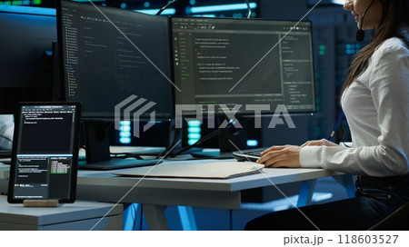 Technician in data center provides technical support to users, troubleshooting issues, close up. Server hub workers carrying out operational technical interventions requested by clients, camera A 118603527