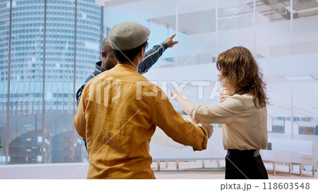 Professional team touring an office space with real estate agent, evaluating building layout and discussing high class urban property investment. Negotiating a deal with financier expert. Camera A. Professional team touring an office space with real estate agent, evaluating building layout and discussing high class urban property investment. Negotiating a deal with financier expert. Camera A. 118603548