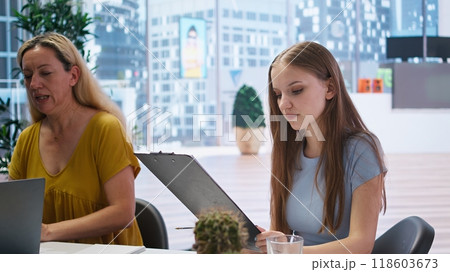 Young adult reading personalized financial plan given by financial advisor during meeting in office. Teenager reading how to make profitable and futureproof economic decisions, camera A 118603673