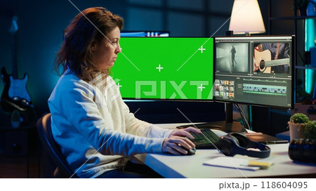 Video editor using editing software on green screen monitor to upgrade footage shot, commissioned by production teams outsourcing tasks. Freelancer videographer finishes project on mockup PC, camera A Video editor using editing software on green screen monitor to upgrade footage shot, commissioned by production teams outsourcing tasks. Freelancer videographer finishes project on mockup PC, camera A 118604095