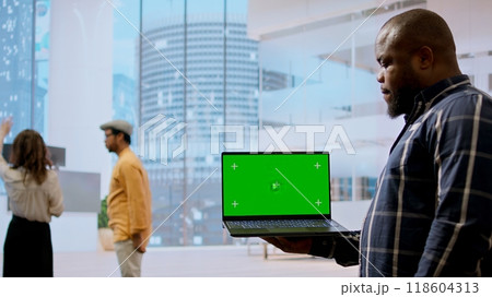 Realtors and client evaluating blueprints next to green screen display, working on new high class office space layout development. Businesswoman sharing her interior design vision. Camera A. Realtors and client evaluating blueprints next to green screen display, working on new high class office space layout development. Businesswoman sharing her interior design vision. Camera A. 118604313