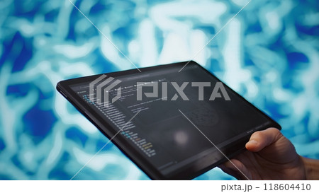 Software developer with tablet programming artificial intelligence computing simulating human brain. Close up of IT professional using device, building AI machine learning algorithms, camera B 118604410