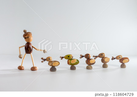 Five handmade ducks made from acorns and twigs, aligned in a row. Unique nature art with one green and four brown ducks. Ideal for autumn decor, eco friendly crafts, and DIY inspiration Five handmade ducks made from acorns and twigs, aligned in a row. Unique nature art with one green and four brown ducks. Ideal for autumn decor, eco friendly crafts, and DIY inspiration 118604729