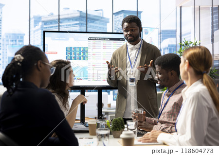 General manager sharing insight on annual infographics reports in enterprise meeting, providing initiatives to enhance operational performance metrics. Group of business associates exchange ideas. 118604778