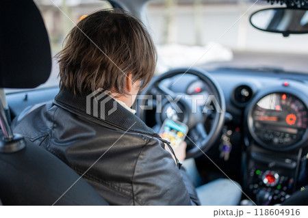 停車中にスマートフォンを操作する男性 停車中にスマートフォンを操作する男性 118604916