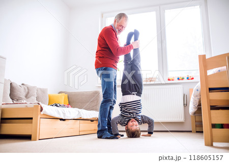 Granddad teaching boy how to make a handstand. Grandfather spending time with grandson, taking care of him while parents are at work. Having fun. 118605157