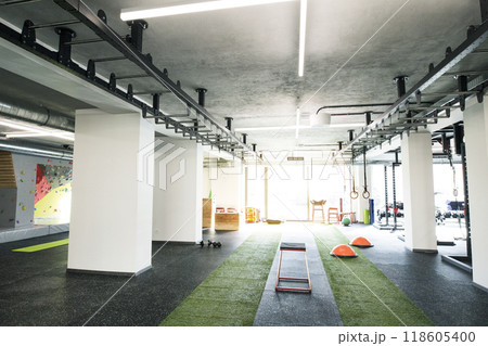 Gym with equipment, metal barbells, dubbells on racks for strength training. 118605400