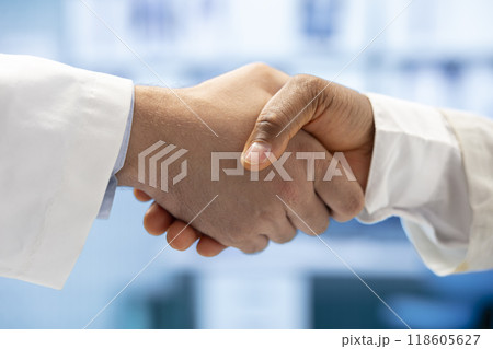 Diverse medics shaking hands after a successful treatment plan collaboration during a meeting with licensed physicians. Doctors with expertise doing a handshake for great partnership. Close up. 118605627