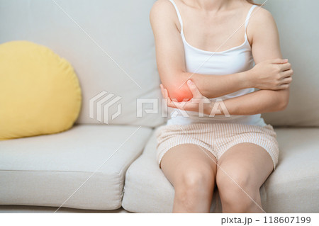 Woman having elbow ache at home, muscle pain due to lateral epicondylitis or tennis elbow. injury, Health and medical concept Woman having elbow ache at home, muscle pain due to lateral epicondylitis or tennis elbow. injury, Health and medical concept 118607199