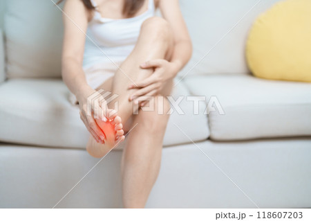 woman having barefoot pain at home. Foot ache due to Plantar fasciitis and waking longtime. Health and medical concept 118607203