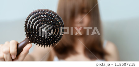 Hair loss problem, Balding , Beauty treatments and health care concepts asian woman holding holding comb with hair loss, young female hold hairbrush and brushing with fall hair from scalp Hair loss problem, Balding , Beauty treatments and health care concepts asian woman holding holding comb with hair loss, young female hold hairbrush and brushing with fall hair from scalp 118607219