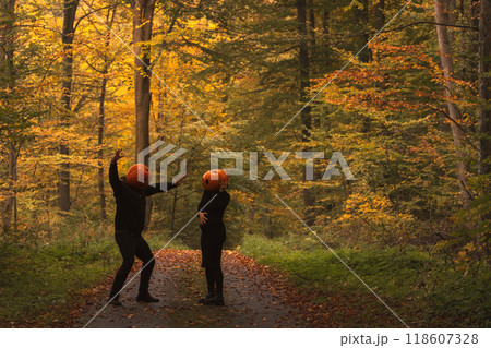 Couple in Pumpkin Heads Amidst Autumn Forest Couple in Pumpkin Heads Amidst Autumn Forest 118607328
