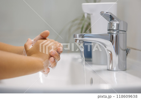 Little girl wash hand after school. White and clean bathroom. Automatic soap dispenser in the bathroom.  118609638
