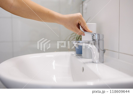 The woman tries to turn on the water in the bathtub, but no water comes out 118609644