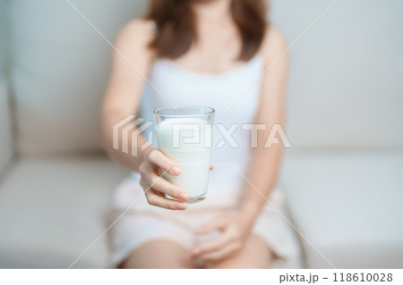 Milk drink and Daily Routine concept. Young woman Drinking milk with high calcium and nutrition at home, woman holding soy milk on glass with protein. Healthy, wellness and happy lifestyle Milk drink and Daily Routine concept. Young woman Drinking milk with high calcium and nutrition at home, woman holding soy milk on glass with protein. Healthy, wellness and happy lifestyle 118610028
