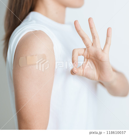 Woman with bandage after receiving vaccine. Vaccination and Immunization for Influenza, HPV, Zoster, IPD, DTP or Diphtheria, Tetanus and Pertussis, MMR, Hepatitis B, Covid  and Varicella vaccine 118610037