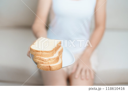Bread eating and Daily Routine concept. Young woman Hand holding sliced whole grain bread in the morning at home 118610416
