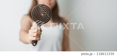 Hair care and Daily routine concepts. asian woman holding holding comb and hair brushing in the morning, young female hold hairbrush with long straight hair at home 118611339