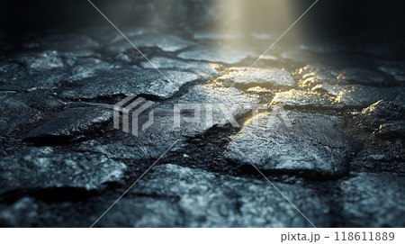 close up view of textured cobblestone surface illuminated by soft light, creating dramatic contrast between shadows and highlights. wet stones reflect light, enhancing atmosphere 118611889