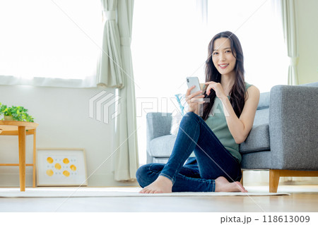 リビングでスマホを見る若い女性 リビングでスマホを見る若い女性 118613009