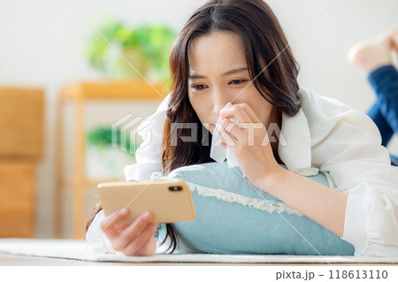 リビングで寝転がりながらスマホを見る女性 リビングで寝転がりながらスマホを見る女性 118613110