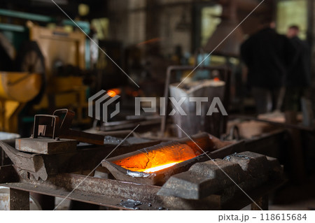 Mold with molten metal in the foundry workshop of metallurgical plant Mold with molten metal in the foundry workshop of metallurgical plant 118615684