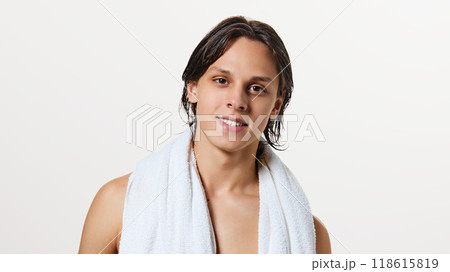Young attractive man, wet after shower with white towel on shoulder looking at camera against white studio background. Young attractive man, wet after shower with white towel on shoulder looking at camera against white studio background. 118615819
