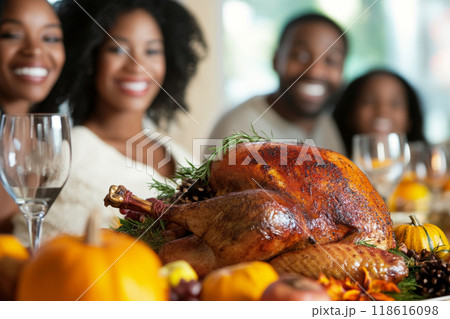 Family enjoying Thanksgiving dinner with roasted turkey on table Family enjoying Thanksgiving dinner with roasted turkey on table 118616098