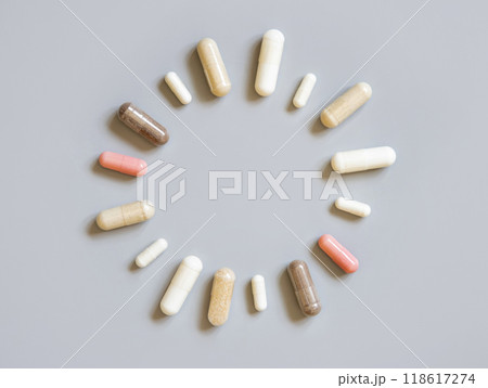 Mix of medical capsules in a circle on grey top view. Taking dietary supplements 118617274