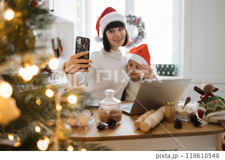 Mother and child celebrating Christmas with selfie at home Mother and child celebrating Christmas with selfie at home 118618548